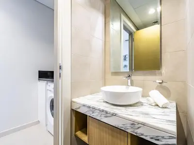 a bathroom with a sink and a washing machine at Modern and Cozy Condo With Unobstructed City Views in Dubai