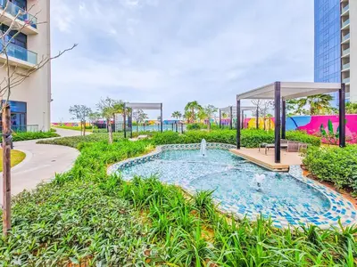 a pool in a park with a gazebo at Modern and Cozy Condo With Unobstructed City Views in Dubai