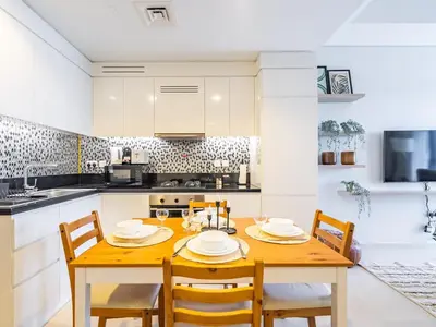 a kitchen with a wooden table and chairs at Modern and Cozy Condo With Unobstructed City Views in Dubai