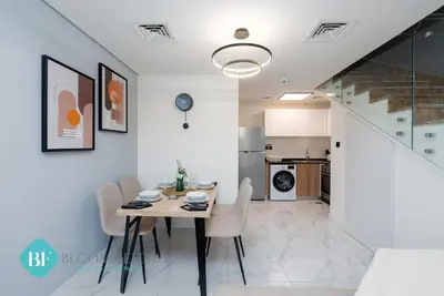 a dining room and kitchen with a table and chairs at Bloomfields Premium 1br Duplex In Rukan in Dubai