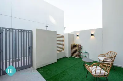 a room with green carpet and two chairs and a table at Bloomfields Premium 1br Duplex In Rukan in Dubai