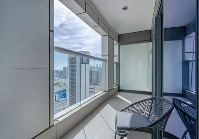a balcony with two chairs and a view of the city at Savis Homes - Damac Paramount Tower A 1BR Ultimate Luxury and Glam Escape in Dubai