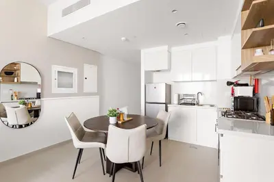 a kitchen and dining room with a table and chairs at Silkhaus High Floor Luxury 1BDR in New Tower in Dubai
