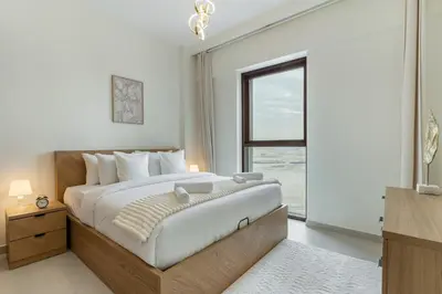 a bedroom with a large bed and a window at Spacious 1-Bedroom in Summer, Lagoon Access Feature - Allsopp&Allsopp in Dubai