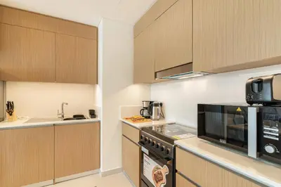 a kitchen with a stove and a microwave at Spacious 1-Bedroom in Summer, Lagoon Access Feature - Allsopp&Allsopp in Dubai