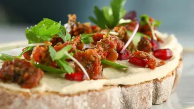a piece of bread with meat and greens on it at InterContinental Residences Dubai Business Bay by IHG in Dubai
