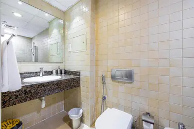 a bathroom with a toilet and a sink and a mirror at Sound of the Waves in JBR by Lagom in Dubai