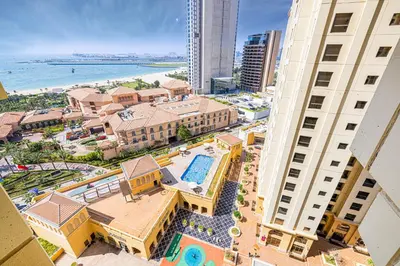 an aerial view of a resort with a pool between two buildings at Sound of the Waves in JBR by Lagom in Dubai