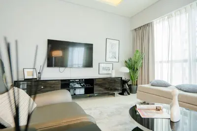a living room with a tv and a couch at Luxe 2BR Haven with Spectacular Burj Khalifa & Dubai Frame Views By ĀYA Boutique in Dubai