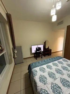 a bedroom with a bed and a flat screen tv at luxury master room available in sulafa tower marina in Dubai