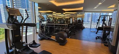 a gym with exercise equipment in a building with skyscrapers at The Star in Dubai