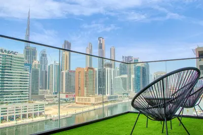 a chair on a balcony with a view of a city at Dubai Skyline Retreat with Burj Khalifa View in Dubai
