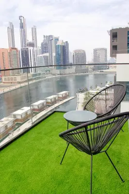 a table and chair on a roof with a view of a city at Dubai Skyline Retreat with Burj Khalifa View in Dubai