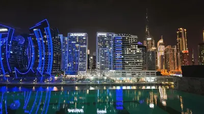 a city skyline at night with blue lights at Dubai Skyline Retreat with Burj Khalifa View in Dubai