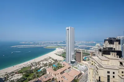 a view of a city with a tall building and a beach at Spacious Full Sea View Full Apartment in Dubai