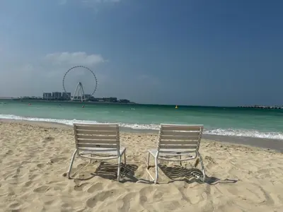 two chairs sitting in the sand on the beach at Spacious Full Sea View Full Apartment in Dubai