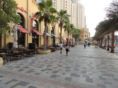 a city street with palm trees and tables and buildings at Spacious Full Sea View Full Apartment in Dubai