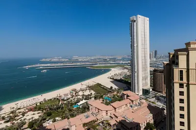 an aerial view of a beach with a tall building at Spacious Full Sea View Full Apartment in Dubai