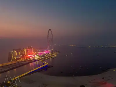 a ferris wheel in the water at night at Beachfront Bliss 2BR Dubai Eye & Full Sea View at the Address Beach By ĀYA Boutique in Dubai