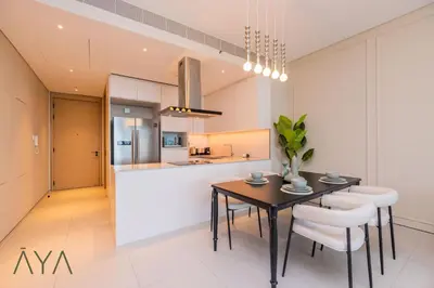 a kitchen and dining room with a table and chairs at Beachfront Bliss 2BR Dubai Eye & Full Sea View at the Address Beach By ĀYA Boutique in Dubai