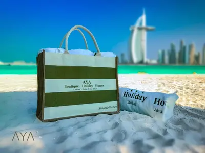 a shopping bag sitting on the sand on a beach at Beachfront Bliss 2BR Dubai Eye & Full Sea View at the Address Beach By ĀYA Boutique in Dubai