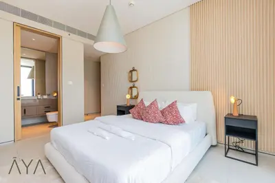a bedroom with a large white bed with red pillows at Beachfront Bliss 2BR Dubai Eye & Full Sea View at the Address Beach By ĀYA Boutique in Dubai