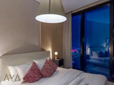 a bedroom with a white bed with a large window at Beachfront Bliss 2BR Dubai Eye & Full Sea View at the Address Beach By ĀYA Boutique in Dubai