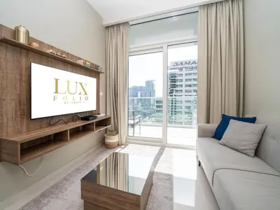 a living room with a couch and a tv at 1 Bedroom Business Bay Bliss with a Canal View in Dubai