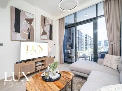 a living room with a couch and a table at Chic 1 Bed Meydan Escape with a Pool View in Dubai