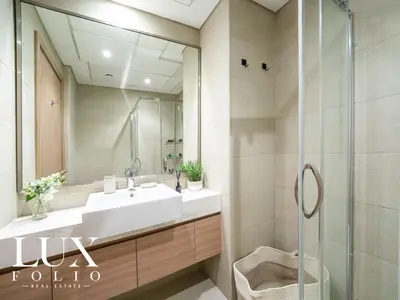 a bathroom with a sink and a shower with a mirror at Chic 1 Bed Meydan Escape with a Pool View in Dubai