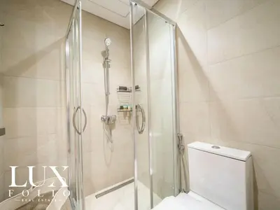 a shower with a glass door in a bathroom at Chic 1 Bed Meydan Escape with a Pool View in Dubai