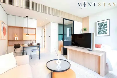 a living room with a couch and a tv and a table at Upside Living, Business Bay Dubai - Mint Stay in Dubai