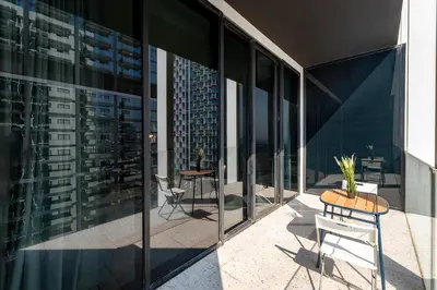 a balcony with a table and chairs on a building at Upside Living, Business Bay Dubai - Mint Stay in Dubai