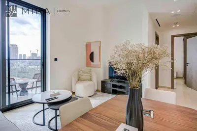 a dining room with a table and a vase with flowers at Mira Holiday Homes - Lovely serviced apartment with pool access in Dubai
