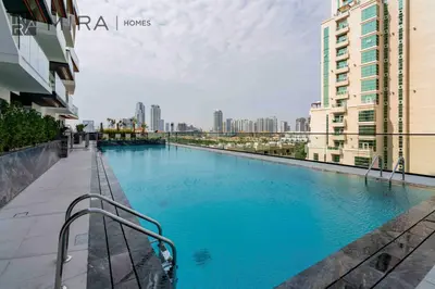 a swimming pool in a city with tall buildings at Mira Holiday Homes - Lovely serviced apartment with pool access in Dubai