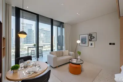 a living room with a table and a couch and a chair at Upside Living, Burj Khalifa View, Business Bay - Mint Stay in Dubai
