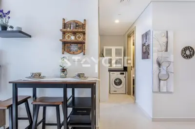 a kitchen with a table and stools in a room at Aykon City Staycae Holiday Homes, Business Bay, Sheikh Zayed Road in Dubai