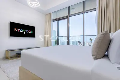 a bedroom with a white bed and a tv at Aykon City Staycae Holiday Homes, Business Bay, Sheikh Zayed Road in Dubai