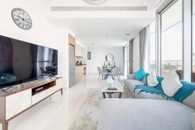 a living room with a couch and a tv at Modern 1BR Oasis in Beach Isle with Beach Access in Dubai