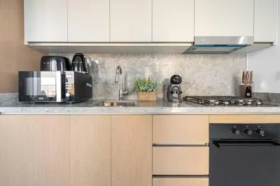 a kitchen with white cabinets and a sink and a stove at Modern 1BR Oasis in Beach Isle with Beach Access in Dubai