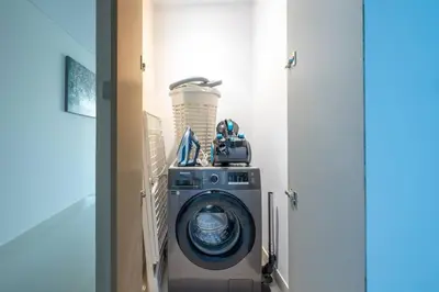 a washing machine in a laundry room with a camera at Modern 1BR Oasis in Beach Isle with Beach Access in Dubai