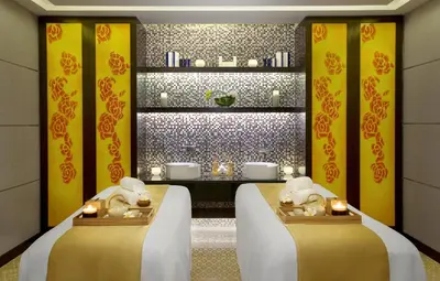 two beds in a room with yellow walls and candles at DAMAC Maison Cour Jardin in Dubai