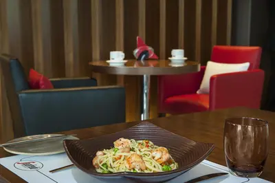 a plate of food sitting on a wooden table at DAMAC Maison Cour Jardin in Dubai