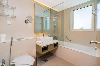 a bathroom with a sink and a mirror and a tub at Escape24 Stylish 2BR Apartment at Damac Maison Privé, Business Bay with Canal View in Dubai