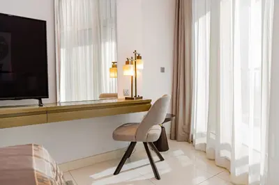 a hotel room with a chair and a television at Escape24 Stylish 2BR Apartment at Damac Maison Privé, Business Bay with Canal View in Dubai