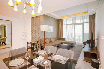 a living room with a dining table and a couch at Escape24 Stylish 2BR Apartment at Damac Maison Privé, Business Bay with Canal View in Dubai