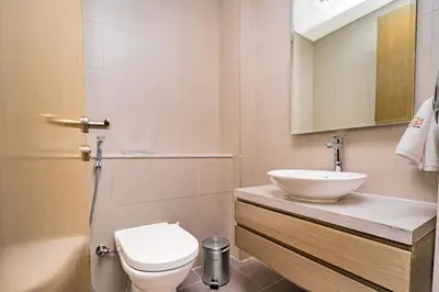 a bathroom with a white toilet and a sink at Escape24 Stylish 2BR Apartment at Damac Maison Privé, Business Bay with Canal View in Dubai