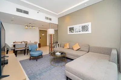 a living room with a couch and a dining room at Escape24 Stylish 2BR Apartment at Damac Maison Privé, Business Bay with Canal View in Dubai