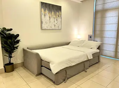 a large bed in a room with a plant at Lux Souk al Bahar Downtown Dubai 1 bedroom flat - Steps to Dubai Mall in Dubai