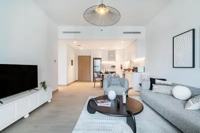 a living room with a couch and a tv at The Smart Concierge - La Rive Port De Lamer in Dubai